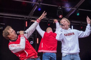 Jochem Myjer en Chris Juffermans zingen Lalala Leiden bij de Minikoraal